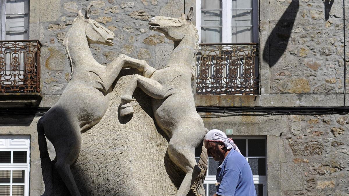 El escultor Manuel Villaverde durante la restauración de la escultura en 2015