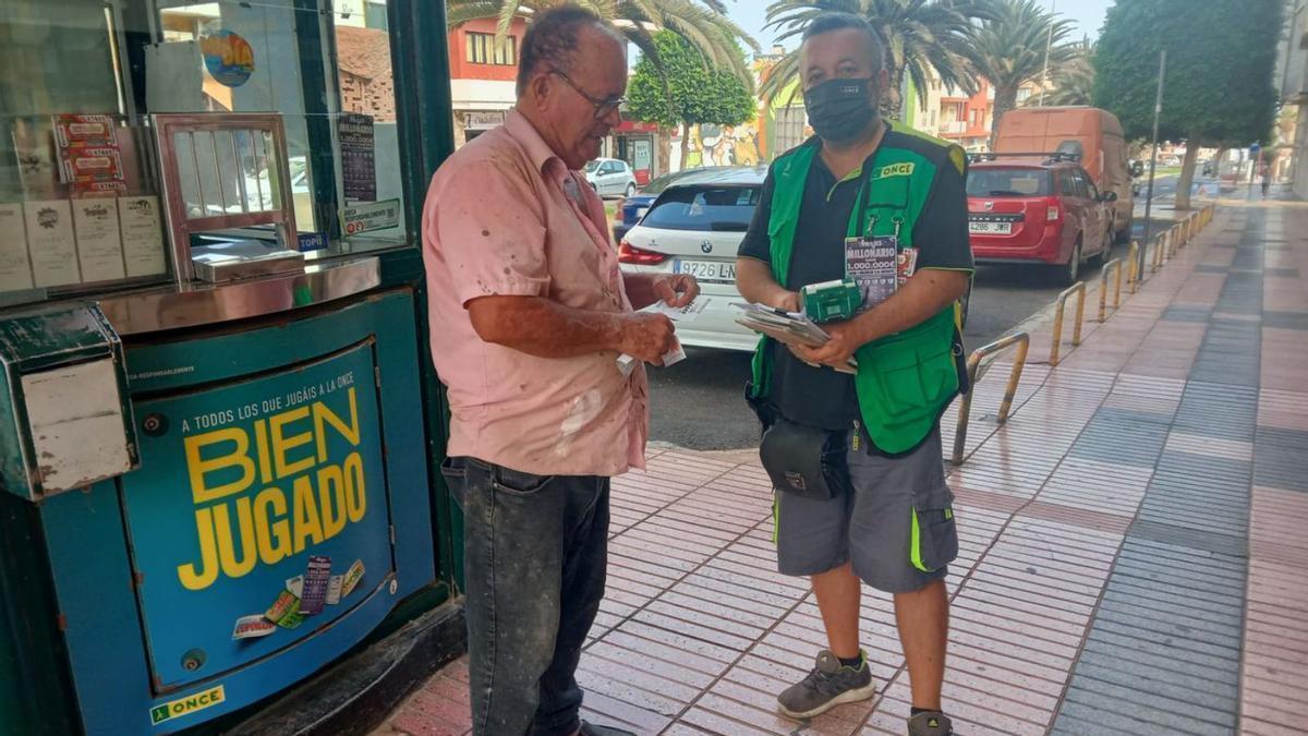 El vendedor de la ONCE José David Santana, vendiendo un cupón a un cliente, ayer. | | LP/DLP