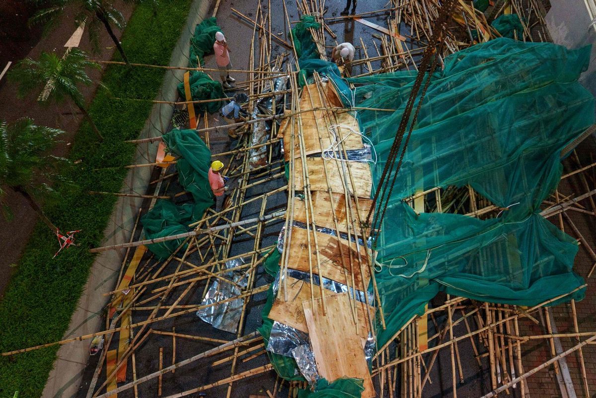 Workers work to remove collapsed scaffolding brought down by strong winds and heavy rain in Hong Kong on July 20, 2025, after Typhoon Wipha skirted along Chinas southern coast. Hong Kong issued its highest tropical cyclone warning July 20 as Typhoon Wipha battered the city, with authorities cancelling classes and grounding hundreds of flights. (Photo by YAN ZHAO / AFP)