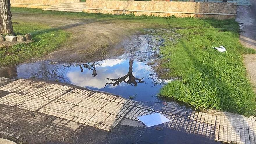 Agua derramada en la acera del parque infantil de Merza. |