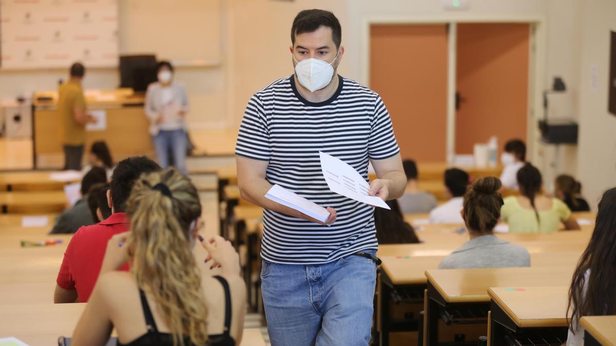 Un joven camina por un aula de Selectividad.