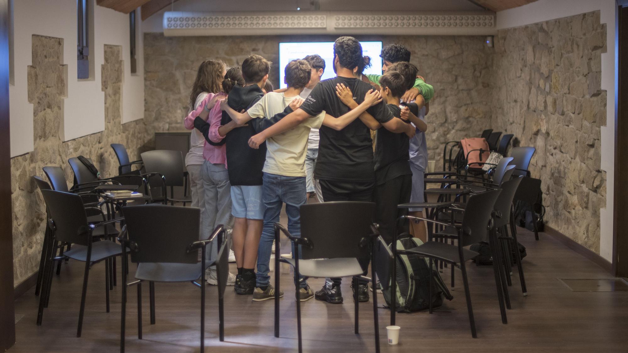 El grupo de menores se abraza al finalizar el taller donde aprenden a gestionar emocionalmente el duelo dentro del programa de Atenció Integral a Personas amb Malalties Avançades de la Fundació La Caixa