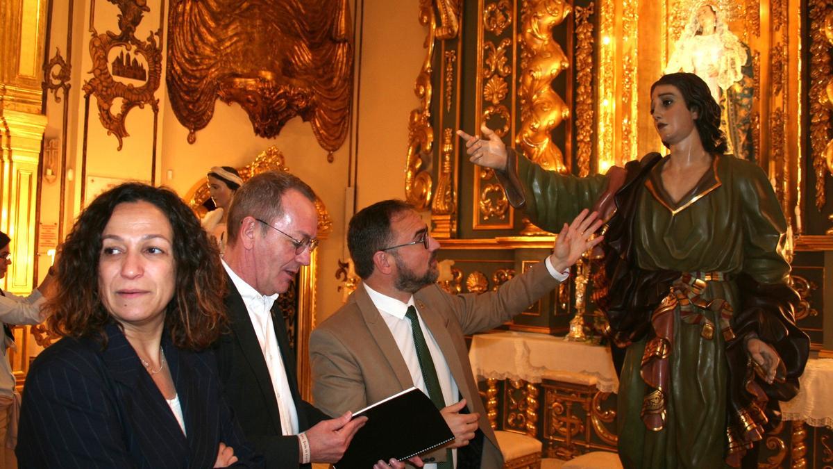 Isabel Casalduero, Ramón Mateos y Diego José Mateos junto a la imagen de San Juan Evangelista en la capilla del Rosario, este miércoles.