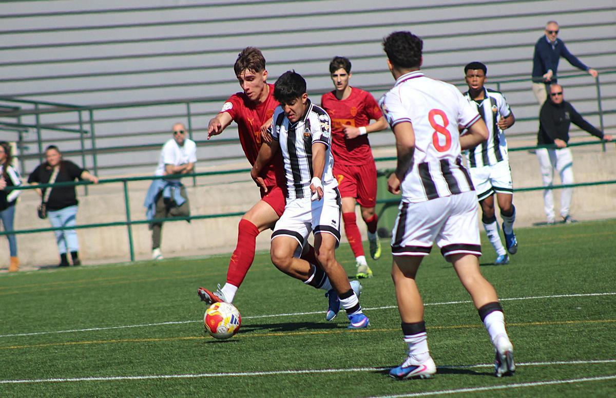 El albinegro Javi Guerra intenta abrirse paso entre los centrocampista del Valencia.