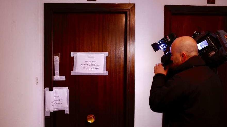 Un cámara de televisión, ante la puerta de la vivienda donde fue el crimen. // Europa Press