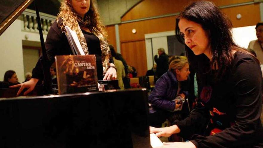 Elisa Rapado toca el piano, con Pilar Vázquez, de pie, en segundo término.
