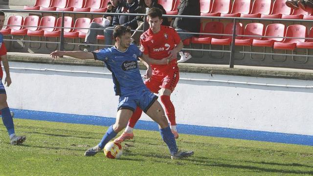 Un jugador del Ourense CF y otro del Osasuna B luchan por el balón. | Iñaki Osorio