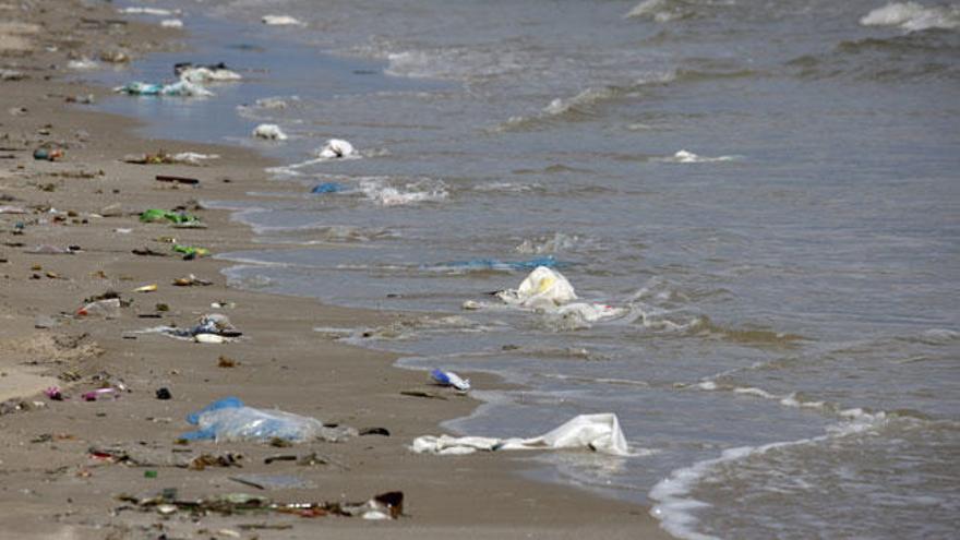 Playa contaminada por botellas y plásticos