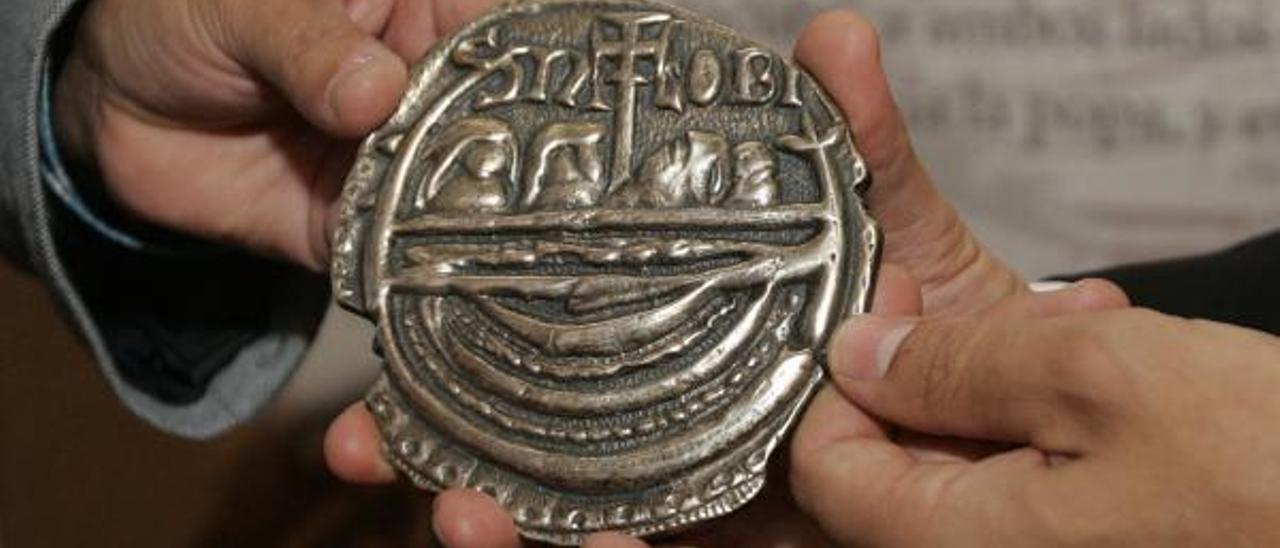 Una réplica de la moneda de Adro Vello, en la que aparece la barca apostólica.