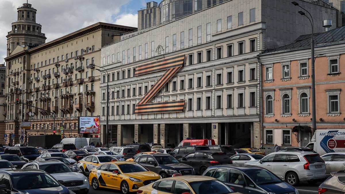Coches atascados en el tráfico frente a un edificio de teatro decorado con la letra Z en Moscú, Rusia