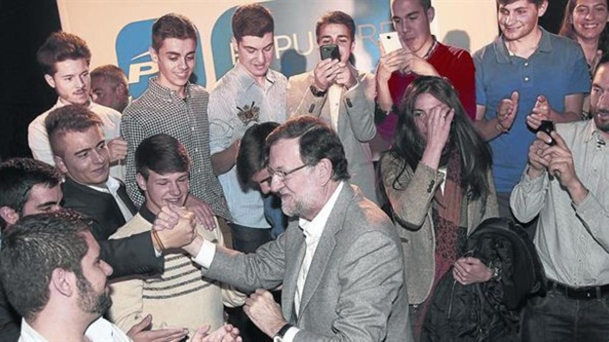 El presidente del Gobierno, Mariano Rajoy, saluda a los jóvenes asistentes al acto de precampaña del PP, ayer en Salamanca.