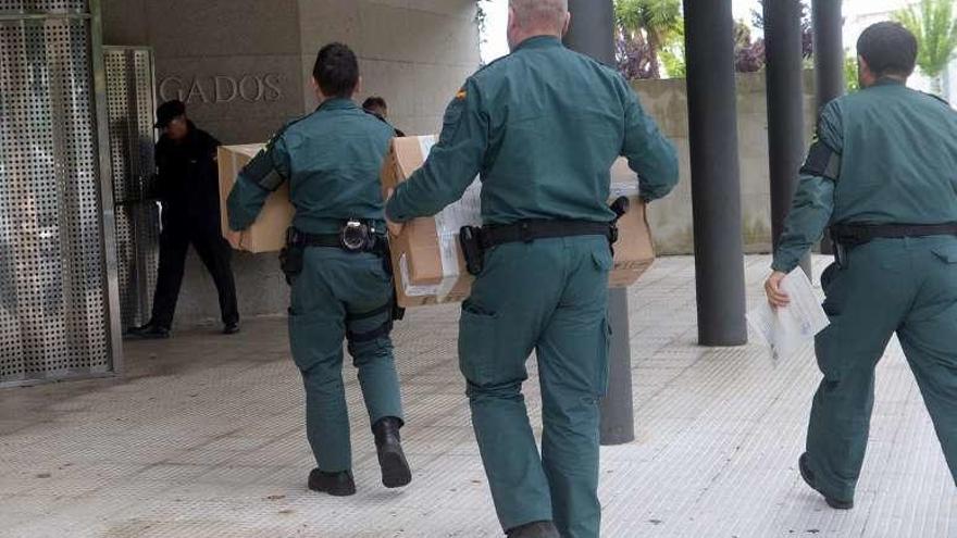 Los guardias llevan la ropa falsificada en cajas al juzgado. // Noé Parga