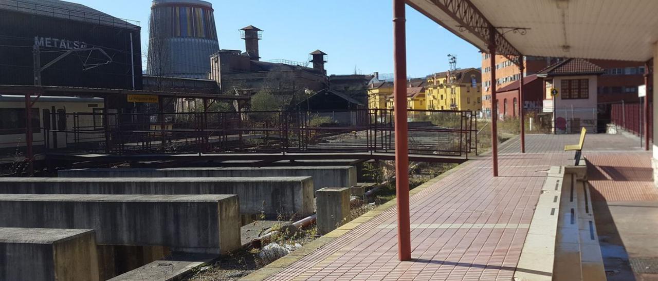 La estación de Feve de La Felguera en primer término, con las naves de Metalsa y el refrigerante (sede actual del Museo de la Siderurgia) al fondo. | L. M. D.