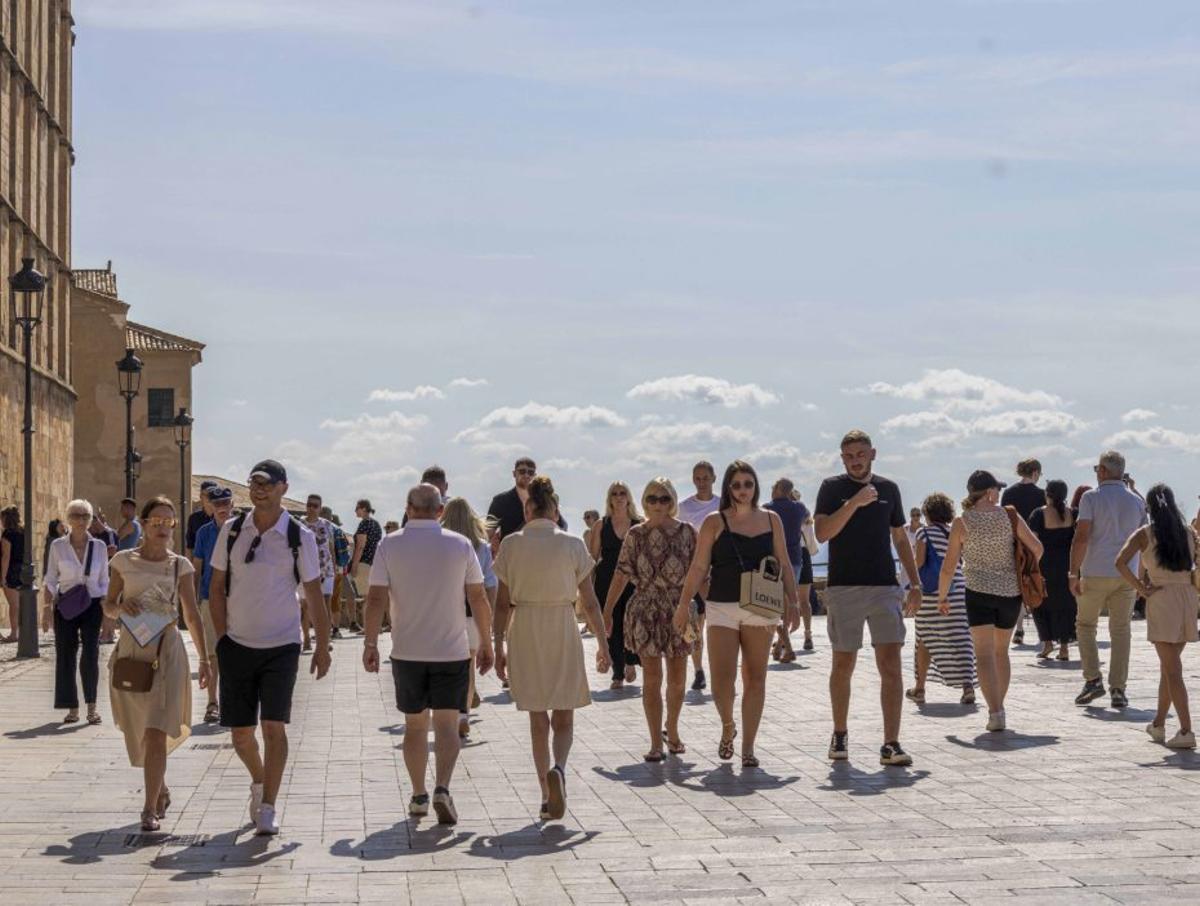 Decenas de turistas pasean frente a la Catedral de Palma.
