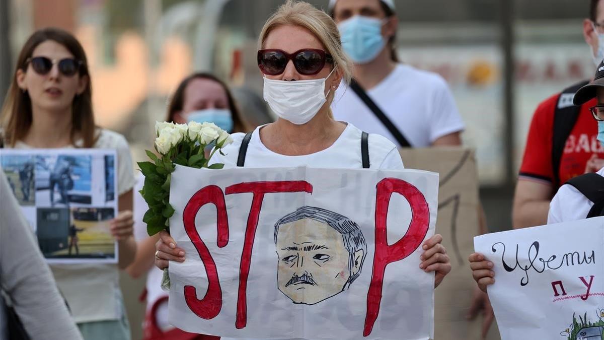 Una manifestante muestra una pancarta en contra de Lukashenko, este sábado en Minsk.