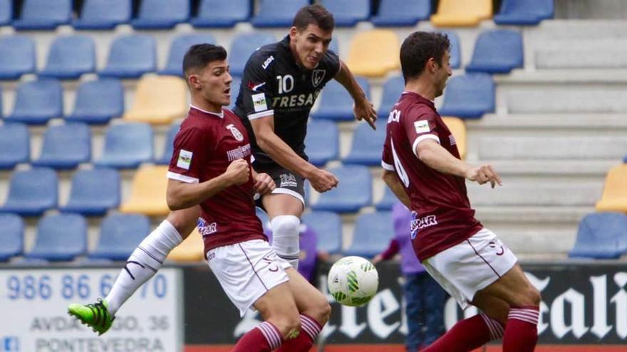 David Grande, ante dos jugadores del Pontevedra, en el choque en Pasarón de esta temporada.