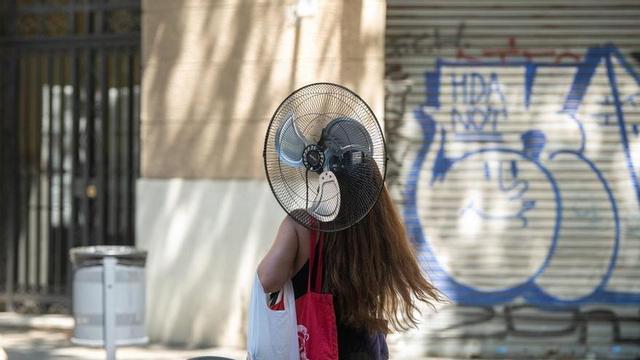 Una noia transportant un ventilador durant la segona onada de calor. Barcelona, 6 de juliol del 2026. Foto: Belén González / EP