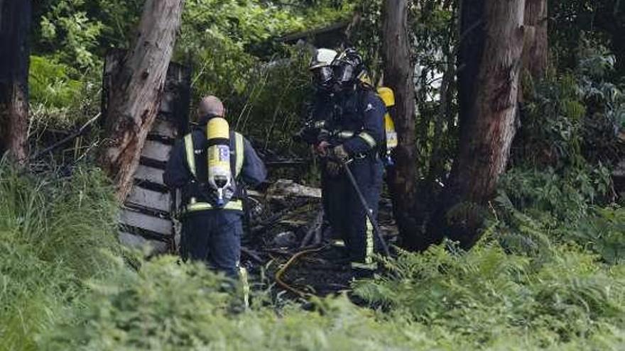 Los bomberos, ayer, apagando el fuego.