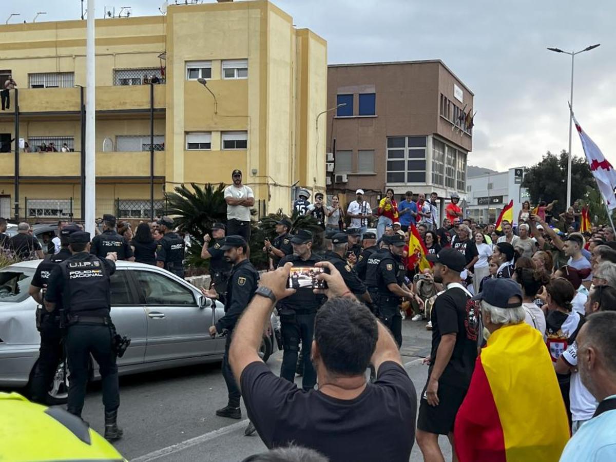 El coche de una diputada ceutí, rodeada de policías durante un tumulto en Ceuta.