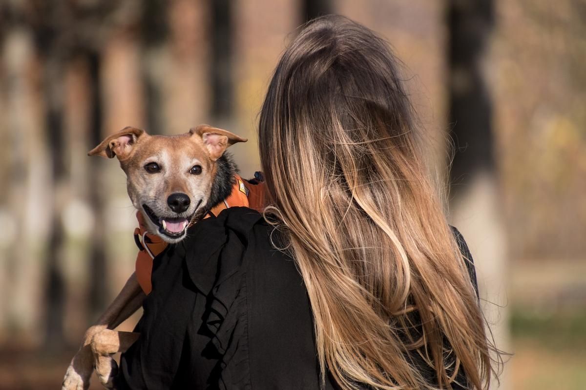 Una mujer sujeta a su mascota.