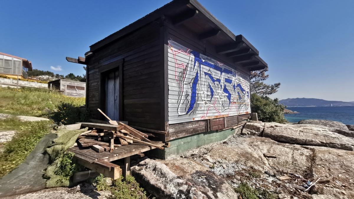 Caseta de madera abandonada en las rocas de la playa.