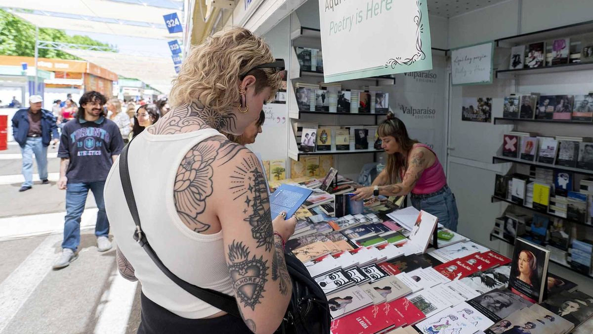 Una lectora hojea un poemario en un puesto de la Feria del Libro de Madrid.