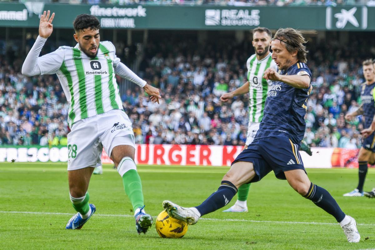 SEVILLA, 09/12/2023.- El defensa hispano-marroquí del Betis Chadi Riad (i) disputa el balón ante Luka Modric (d), centrocampista croata del Real Madrid, durante el partido de la Jornada 16 de LaLiga que Betis y Real Madrid disputan este sábado en el estadio Benito Villamarín en Sevilla. EFE/ Raúl Caro