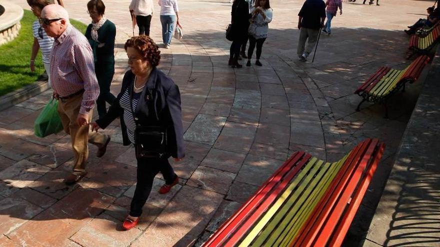 Varios bancos de la plaza de la Escandalera, ayer, pintados con los colores de la bandera de España.