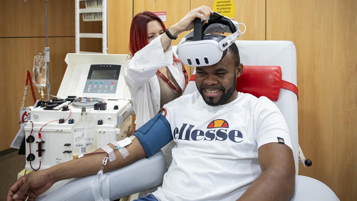 Una treballadora del Banc de Sang i Teixits posa les ulles virtuals a un donant