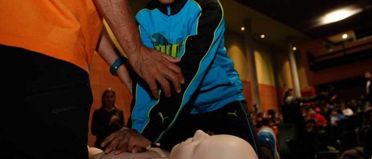 El alumno del colegio Asturias Renato Acevedo realiza una reanimación cardiopulmonar a un muñeco.