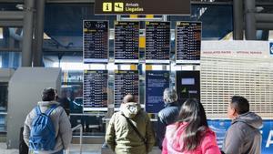 Varias personas observan los paneles informativos que anuncian retrasos de llegadas en algunos vuelos de Iberia en la Terminal 4 del Aeropuerto Madrid-Barajas Adolfo Suárez, a 28 de enero de 2023, en Madrid (España).