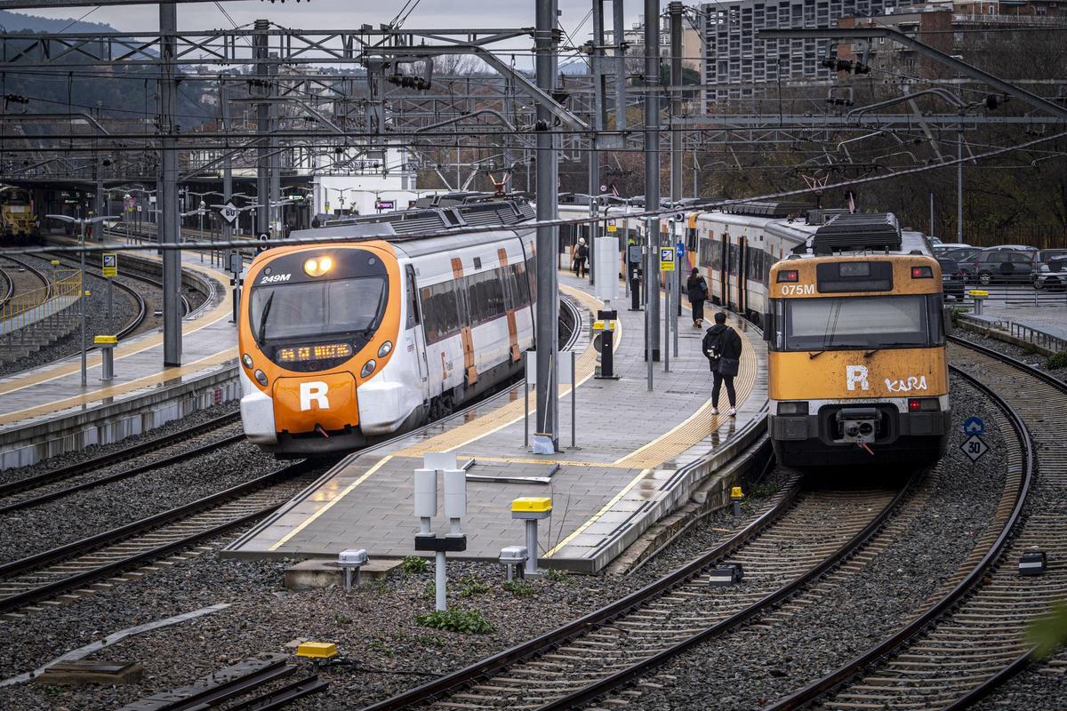 Dos trens de Renfe i usuaris de la línia a l'estació de Manresa