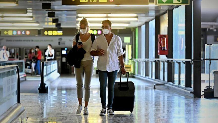 Una pareja de turistas caminan por el aeropuerto.