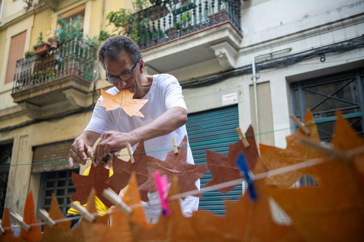 Un vecino de la calle Tordera poniendo a secar las hojas que están haciendo para los ‘guarniments’ de las fiestas mayores de Gràcia. Este año, 5 calles del barrio se han unido bajo la temática de ‘El Señor de los Anillos’. Barcelona, 4 de agosto de 2026. Foto: Belén González / EP