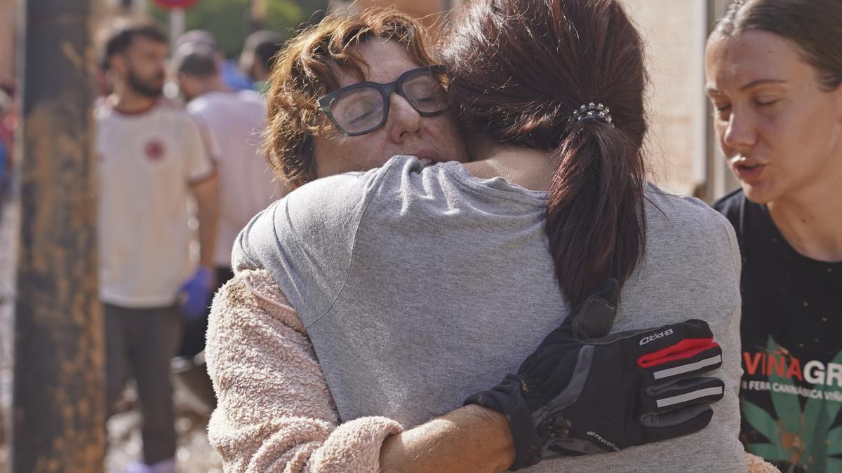 Dos mujeres se abrazan tras las inundaciones en Massanassa, a las afueras de Valencia.