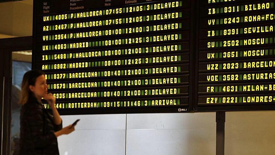 Una pasajera contempla las pantallas de vuelos en el aeropuerto de Manises.