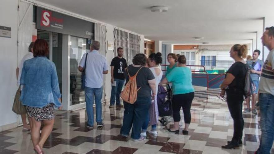 Ciudadanos en la puerta de una oficina del Servef de Elche.