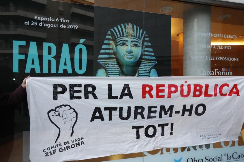 Els manifestant fan pintades i empaperen l'entrada de la seu de CaixaBank a Girona