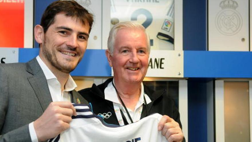 Craig Reedie recibe una camiseta de manos de Casillas.