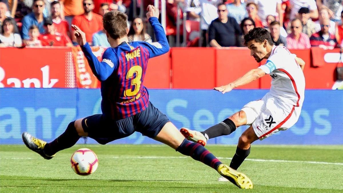 Navas dispara ante Piqué para marcar el primer gol del Sevilla contra el Barça.