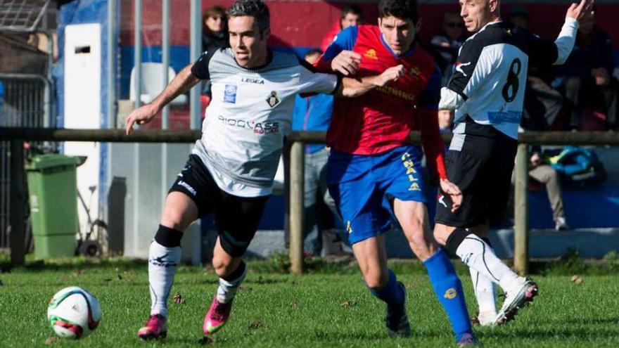 El jugador del Caudal Invernón, con el balón, presionado por el condalista Carly.