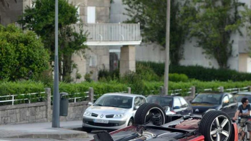 El coche volcado ocupaba parte de la calzada y de la acera. // G. S.