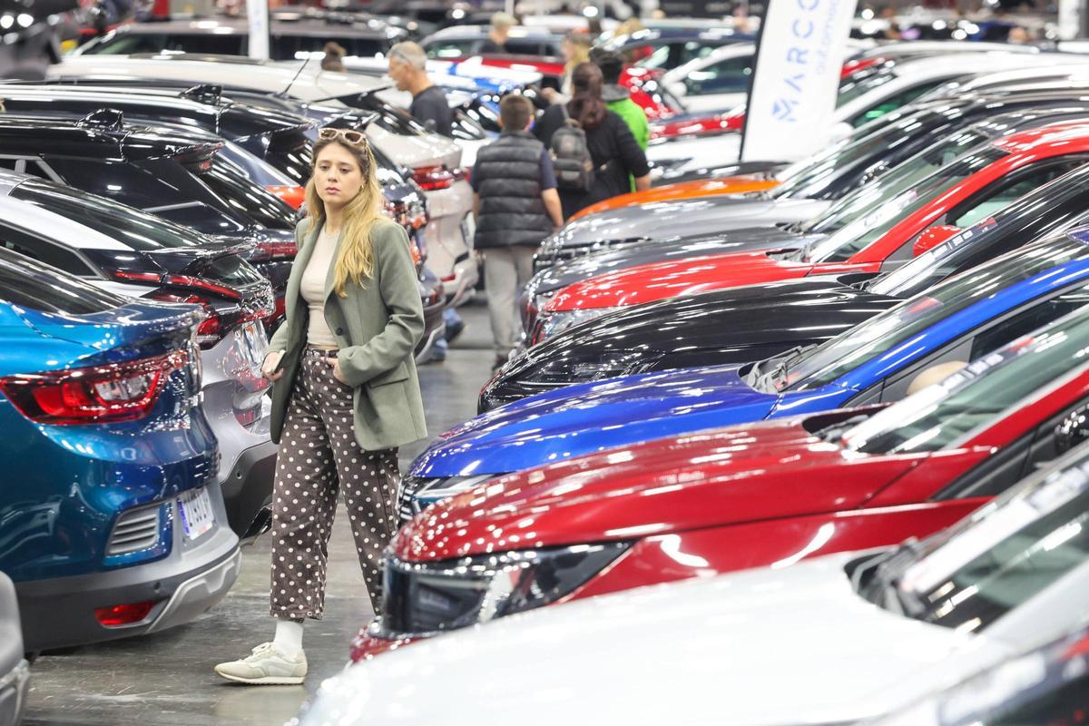 Una mujer pasea entre vehículos en la feria