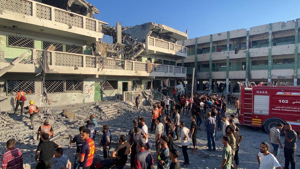 Palestinos inspeccionan el lugar de los ataques israelíes contra una escuela que acoge a desplazados en Sheij Radwan, Ciudad de Gaza