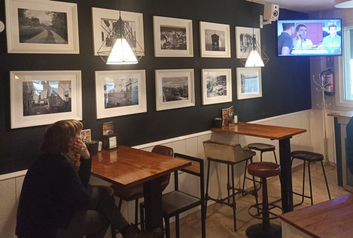 Una mujer observa la televisión en un bar de Huesa.