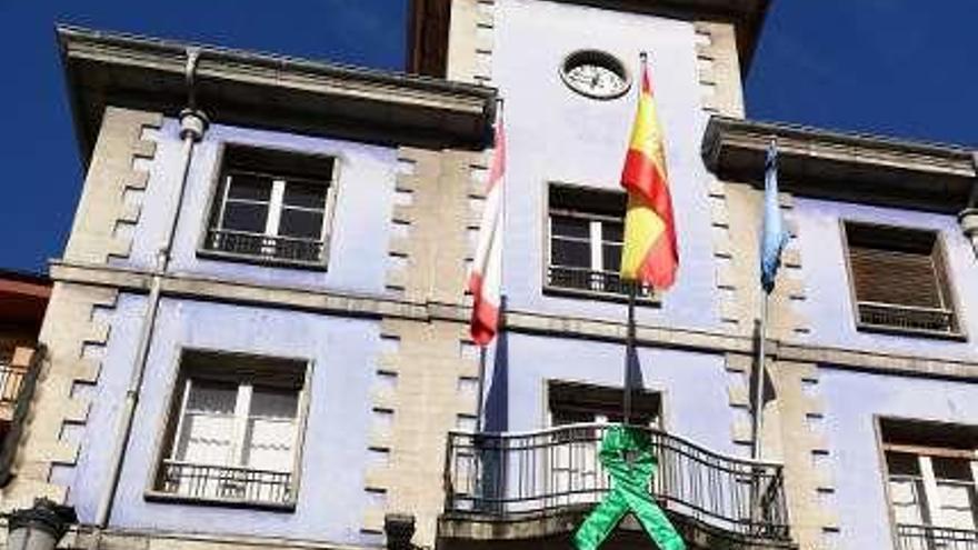 El antiguo Ayuntamiento de Candás, con un gran lazo verde en su balcón.