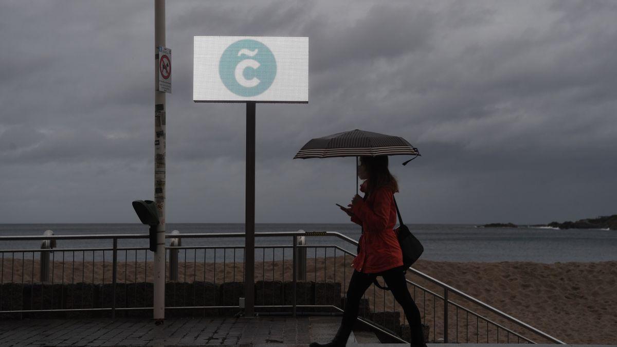 Una mujer se protege de la lluvia en A Coruña.