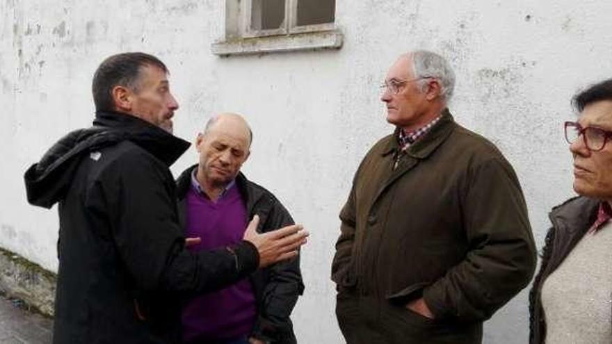 Matías Rodríguez conversa con vecinos de Lebredo en presencia de Carmen Pérez García de la Mata, a la derecha.