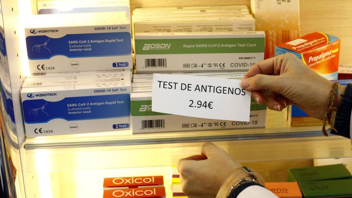 La farmacéutica Elena Brosed coloca el nuevo precio de los test de antígenos, el sábado pasado.  | JAIME GALINDO