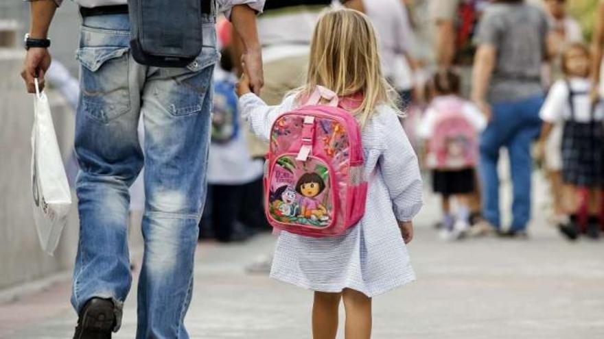 Un hombre camina con su hija hacia el colegio. / efe